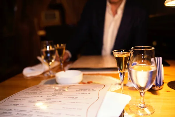 Een glas water en alcohol op de tafel in het restaurant. me — Stockfoto