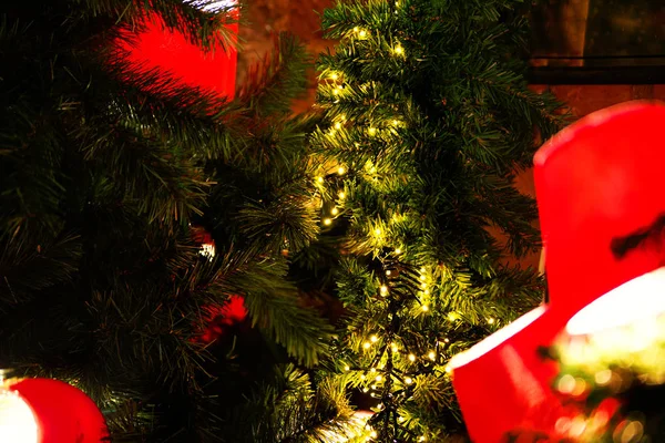 Τα κόκκινα φανάρια πάνω σε ένα κλαδί ενός χριστουγεννιάτικου δέντρου πάνω σε φόντο κόκκινο τούβλο τοίχο — Φωτογραφία Αρχείου