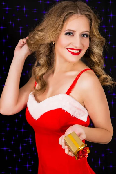 Šťastná žena v šatech Santa dárek na černém pozadí — Stock fotografie