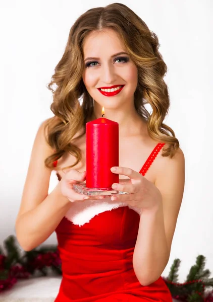 Hezká žena v Santa šaty se svíčkou — Stock fotografie
