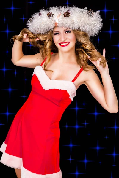 Pretty woman s vánoční věnec na černé poza — Stock fotografie