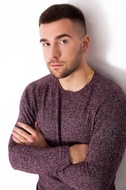 Yakışıklı adam çapraz kolları üzerinde beyaz bir arka plan izole olan ayakta