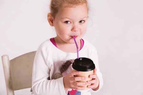 Menina segurando uma xícara de café de papel para tirar e sorrir — Fotografia de Stock
