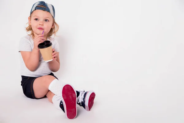 Petite fille dans un style sportif avec un verre de café à la main — Photo