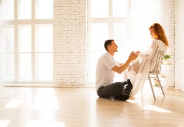 katta, hamile kadın bir sandalyede oturan kocası. Kocası sevgiyle karısına görünüyor