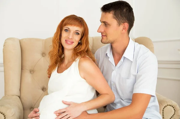 Gelukkige toekomstige ouders zittend op de Bank — Stockfoto