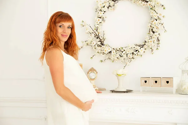 Hermosa mujer embarazada en decoraciones blancas —  Fotos de Stock