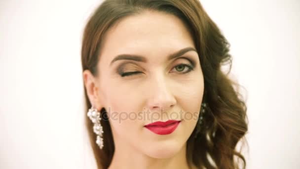 Krásná žena s večerní make-up vypadá na kameru a mrknutí — Stock video