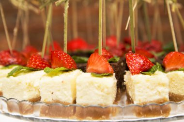 Peynir ve çikolatalı cheesecakes çilek üzerinde bir tuğla ile arka plan duvar