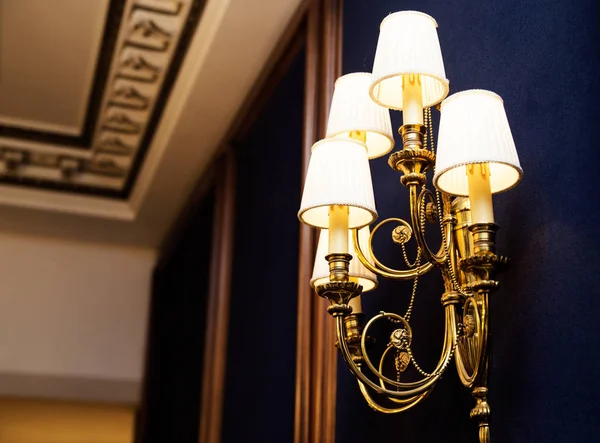 Lamps and chandelier in the classic interior of the hotel
