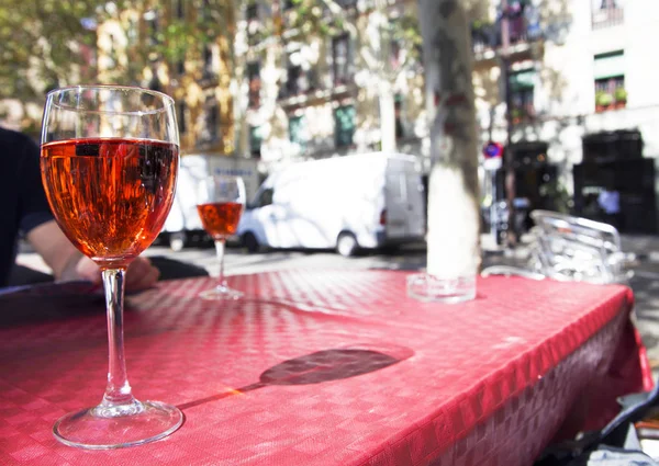 Um copo de vinho tinto na mesa de um café de rua em um dia ensolarado brilhante — Fotografia de Stock