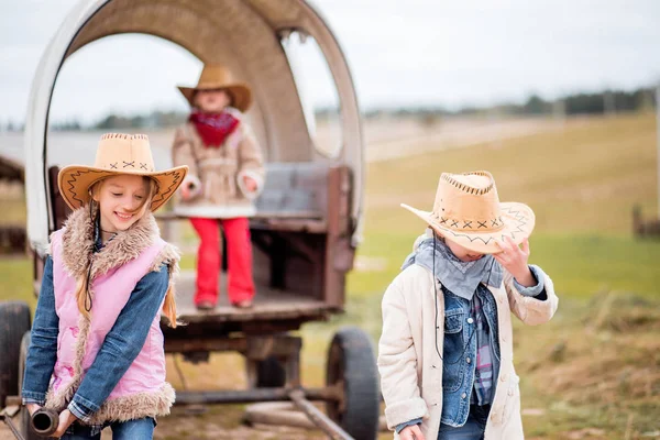 three sisters have fun on the farm near the old cart