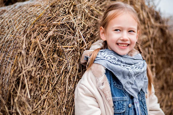 Una niña alegre al lado de un pajar —  Fotos de Stock