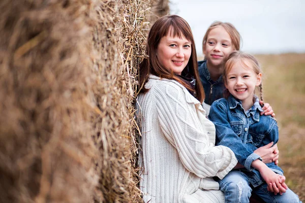 Famiglia madre e due figlie stanno riposando vicino al fieno — Foto Stock