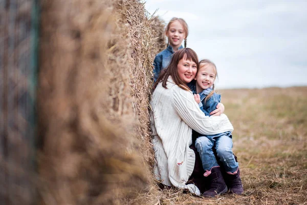 Famiglia madre e due figlie stanno riposando vicino al fieno — Foto Stock