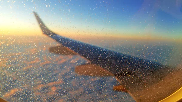 Снежинки на окне самолета во время полета — стоковое фото