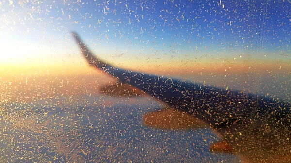 Снежинки на окне самолета во время полета — стоковое фото