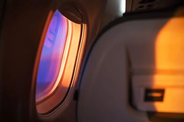 Ablak repülőgép, repülés közben. Narancs-lila tónusokkal Hajnal — Stock Fotó