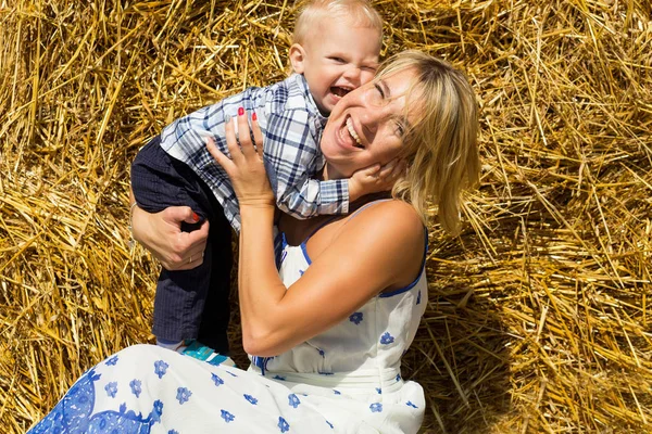 Mamma e piccolo figlio insieme sullo sfondo di un pagliaio in un — Foto Stock