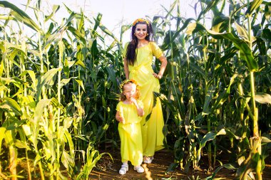 Anne ve kızı aynı sarı elbiseler ortasında bir 