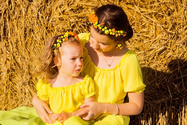 Mamá e hija en vestidos amarillos se están divirtiendo juntas —  Fotos de Stock