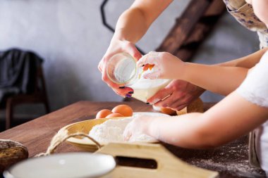 Anne ve kızı birlikte un, yumurta ve süt pişer