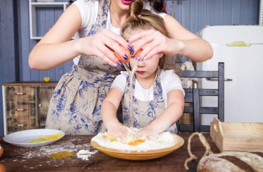 Anne ve kızı birlikte un, yumurta ve süt pişer