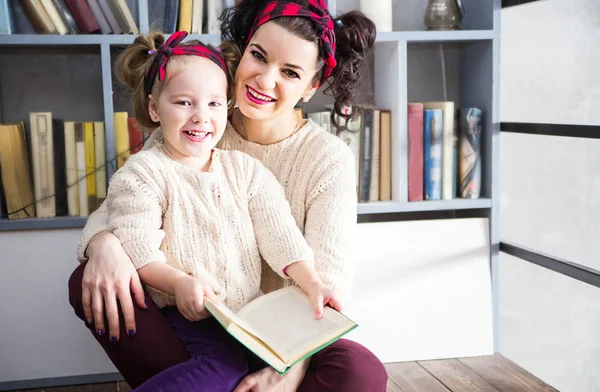 Madre e hija están sentadas en el suelo y leyendo — Foto de Stock