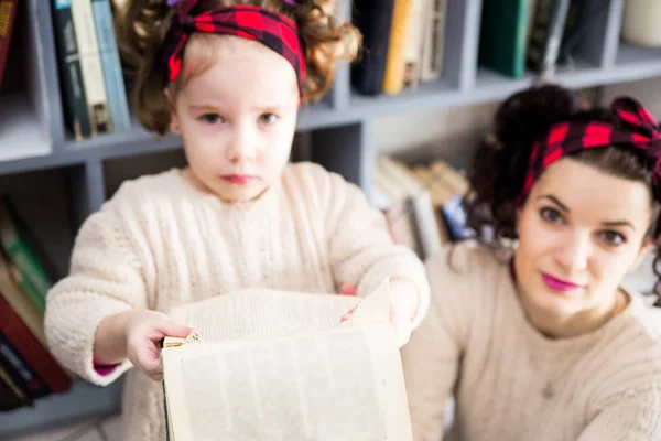 小さな女の子と彼女のお母さんが破れた本のため怒っています。 — ストック写真