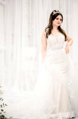 Beyaz bir arka plan karşı uzun beyaz bir elbise içinde gelin