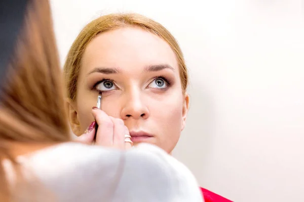 Make-up artist does make-up for the model — Stock Photo, Image