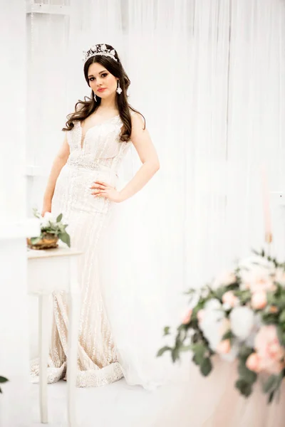 Braut im langen weißen Kleid vor weißem Hintergrund — Stockfoto