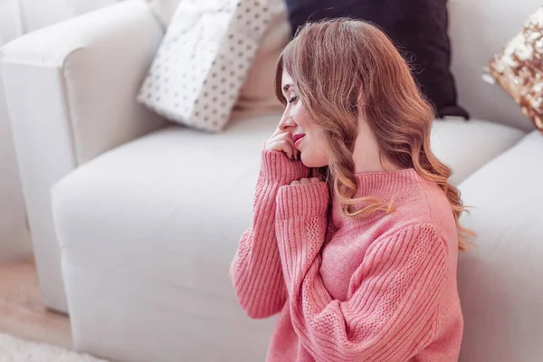 Hermosa chica en un suéter rosa se sienta en un ambiente acogedor en casa —  Fotos de Stock