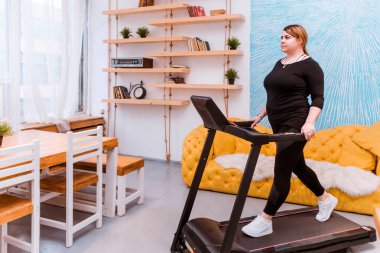 Manken - şişman bir kadın, kilo vermeye çalışıyor ve evde koşu bandına takılıyor..