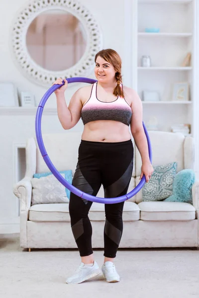 Модель толстая женщина, пытается похудеть дома и делает упражнения с halajup — стоковое фото