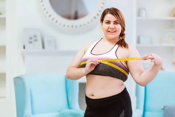 Modelo - mulher gorda, medindo o tamanho da cintura com uma fita métrica — Fotografia de Stock