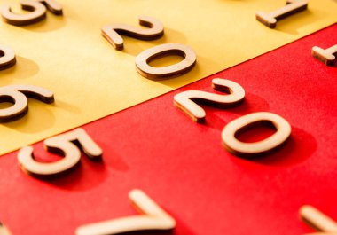 Birçok rakam arasında kırmızı ve sarı arkaplan üzerinde 2020 rakamları. Yukarıdan bak. Gölge arka plana düşer