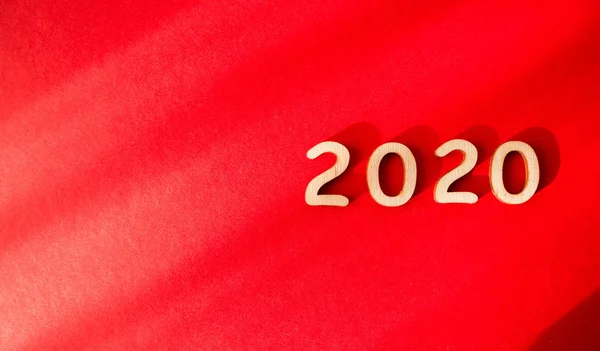 Digits 2020 on a red background. View from above. Shadow falls on the background — Stock Photo, Image