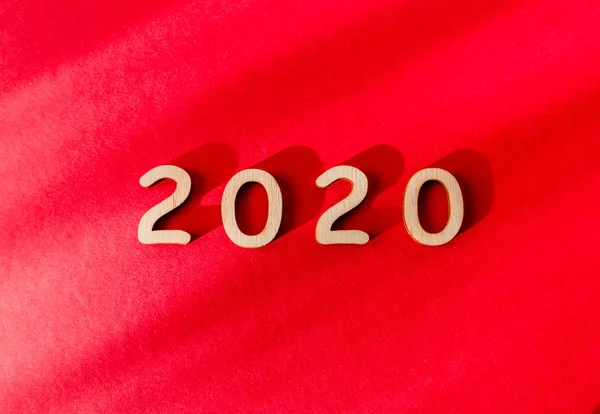 Digits 2020 on a red background. View from above. Shadow falls on the background — Stock Photo, Image