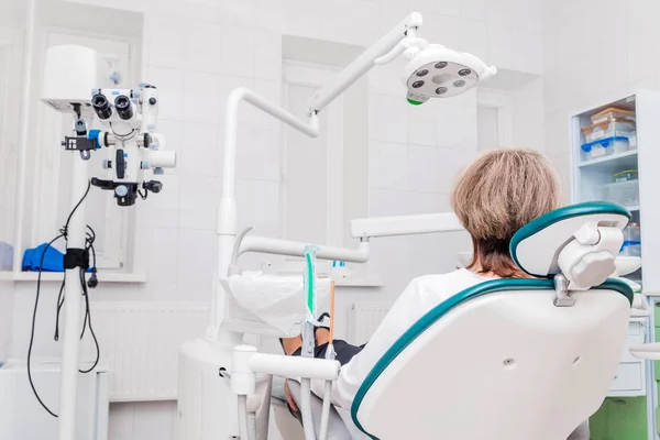 치과 의자에 앉아 있는 치과를 방문하는 여성 환자의 뒷모습. 임상 기형학 — 스톡 사진