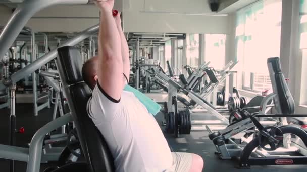 Homem Ginásio Faz Exercício Nos Braços Ombros Simulador — Vídeo de Stock
