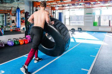 Gömleksiz adam ağır lastik spor salonunda saygısız