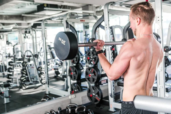 스포츠, 보디 빌딩, 라이프 스타일과 사람 개념-바 벨 헬스 클럽에서 근육을 flexing과 젊은 남자 — 스톡 사진