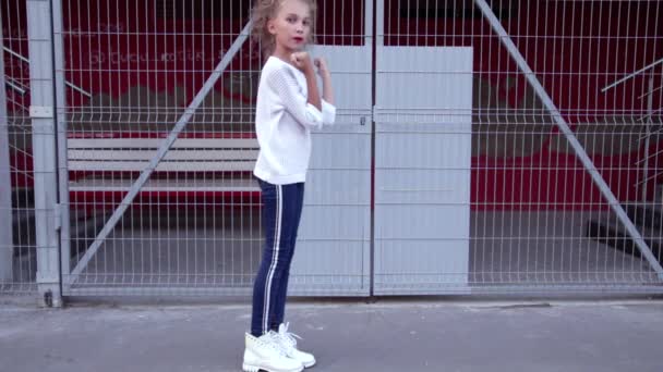 Gekruld Blond Meisje Een Witte Trui Blauwe Jeans Danst Achtergrond — Stockvideo