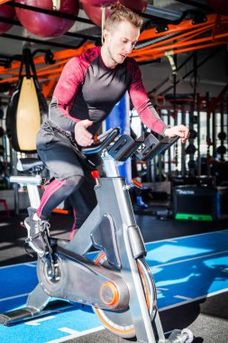 Sporcu güneşli bir havada bir spor salonunda kardiyovasküler ekipmanla meşgul..