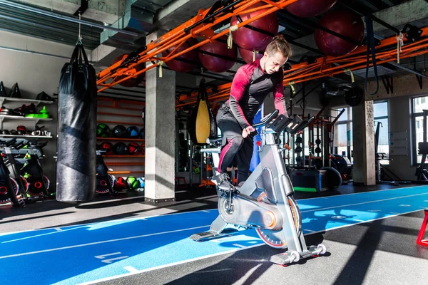 El atleta se dedica a un equipo cardiovascular en un centro de fitness en tiempo soleado . — Foto de Stock