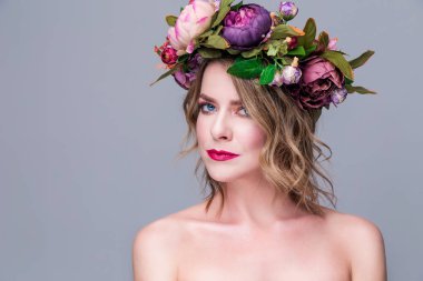 Gri arka planda parlak çiçekleri olan güzel bir kadın model.