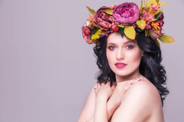 Mor arka planda parlak çiçekli güzel esmer kadın manken.