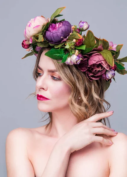 Красивая молодая женщина модель с яркими цветами на голове на сером фоне — стоковое фото