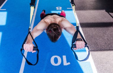 Spor salonunda güçlü karın kasları için spor yapan bir adam spor salonunda spor yapıyor.